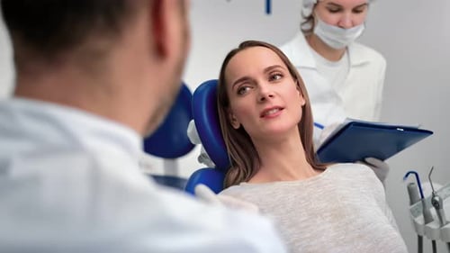 Gesicht der Patientin hört aufmerksam zu Zahnarzt sitzt am Dentalsessel