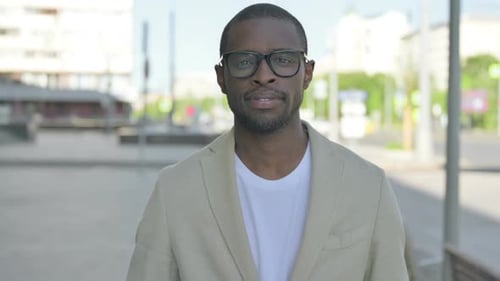 Man in Blazer Standing in Urban Setting