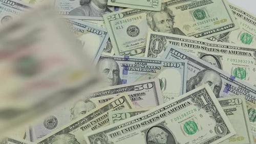 Les billets d'un dollar tombent sur la table avec des dollars américains de différentes dénominations