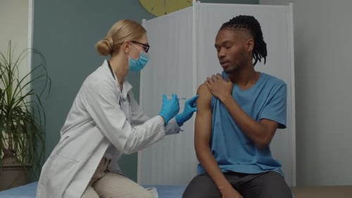 Doctor Gives Injection to Young Adult Patient