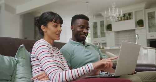 Couple Using Laptop Together on Couch in Home