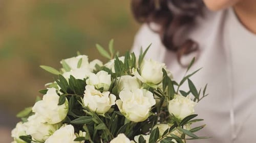 Elegant Woman Holding a Bouquet of White Roses