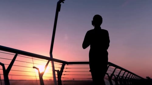 Woman Running Silhouette on Bridge at Sunrise