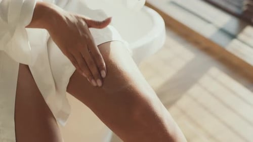 Woman Applying Lotion to Leg for Skincare