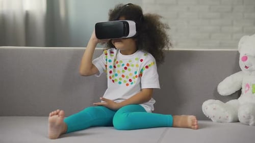 Girl Experiences Virtual Reality on Headset Indoors