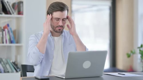 Man Working At Laptop Gets Headache