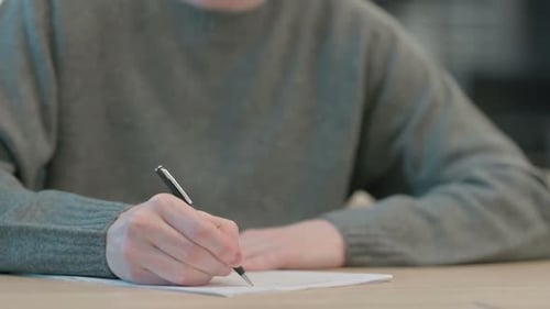 Nahaufnahme der Hände des Menschen, die auf Papier schreiben