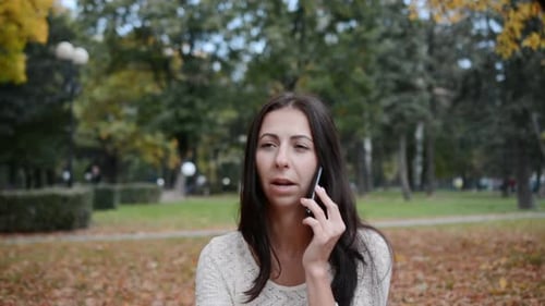 Woman Talking on Phone in Park, Upset