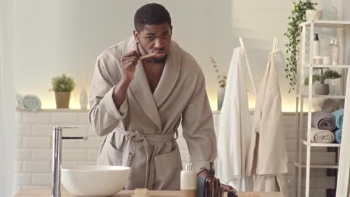 Young Adult Brushing Teeth in Modern Bathroom