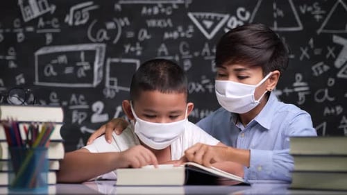 Young Adult Tutoring Child With Schoolwork at Table