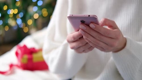 Close Up Woman Hands Using Mobile Phone on Christmas Background