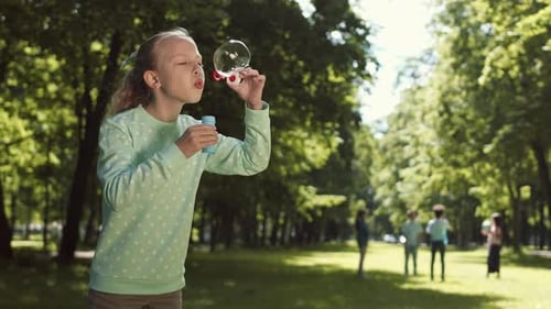 Girl with Soap Bubbles in Park