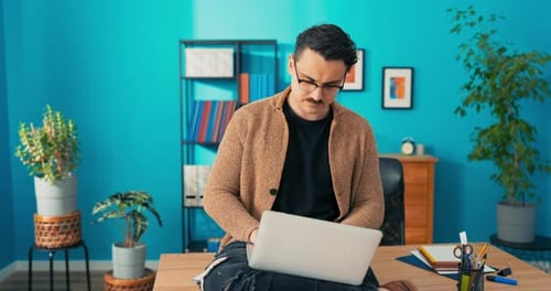 Comfortably Elegantly Dressed Man Working in Office Sits at Desk with Laptop on Lap Ambitious
