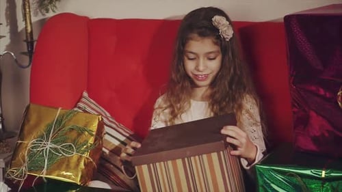 Happy Girl Opening a Christmas Gift Present