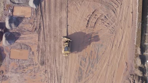 Tractor Moving Dirt on Construction Site Aerial View