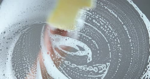Hand Cleaning Glass with Soapy Sponge