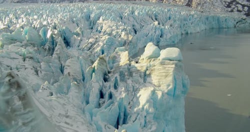 Aerial helicopter shot, overhead details of a craggy glacier, blue and white ice, some pollution vis