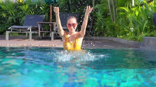 Young asian woman enjoy around outdoor swimming pool for leisure