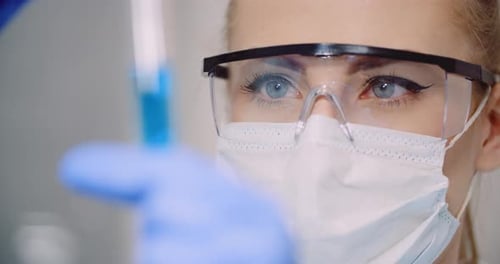 Close Up of a Woman Scientist Looking at Test Tube