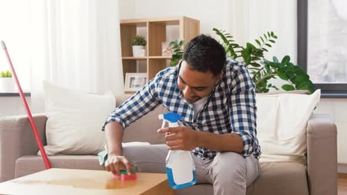 Man Cleaning Table in Bright Living Room