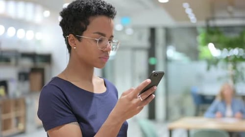 Young Woman Using Smartphone in Modern Office