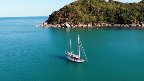 Boat Near Tropical Shore. Amazing Drone View of Modern Yacht Sailing on Calm Sea Water Near Coast of
