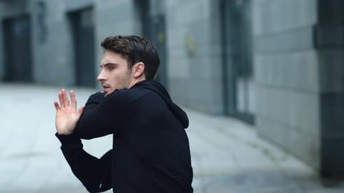 Man Stretching Arms Outdoors in Urban Setting