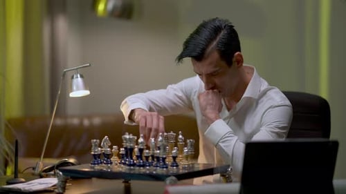 Konzentrierter Schachspieler sitzt zu Hause am Tisch und übt