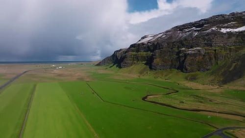 Verdant Fields and Rugged Mountains Aerial View