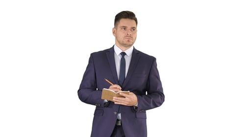 Thoughtful Man in Suit Writing in Notepad