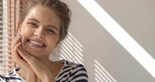 close up shot of happy pretty Caucasian woman smiling and looking at camera, slow motion
