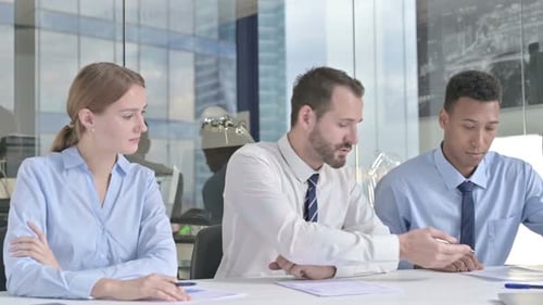 Middle Aged Businessman Explaining on Documents To His Assistants in Office