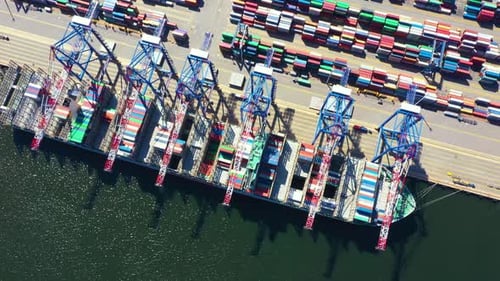 Container ship in export and import business and logistics. Shipping cargo to harbor by crane. Water