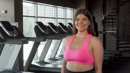 Young Woman Smiles, Working Out at the Gym