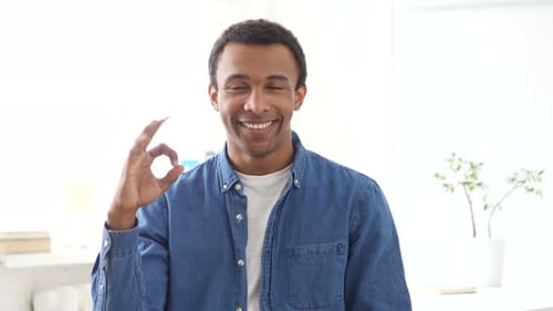 Young Adult Gives Okay Hand Gesture and Smiles