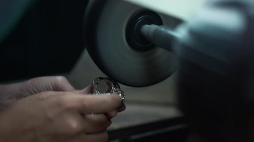 Closeup Female Hands Polishing Silver Ring with Equipment in Workshop