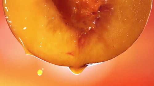 Slow Motion Macro Shot of Flowing Peach Juice From Half Peach