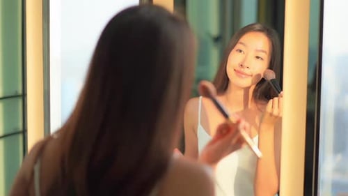 Young asian woman check her face on mirror