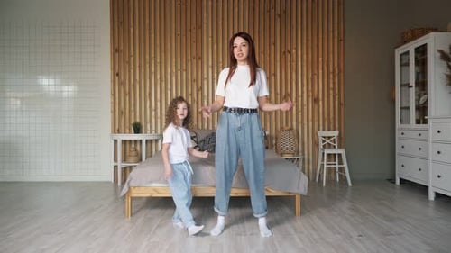 Woman and Child Dancing Together in Bedroom