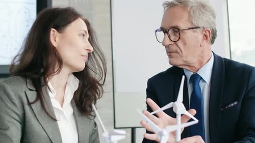 Professionals Discussing Wind Turbines in Office