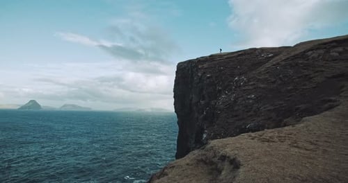 Man stands at the edge of a cliff