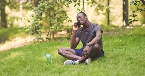 Man Talking on Phone While Sitting on Grass