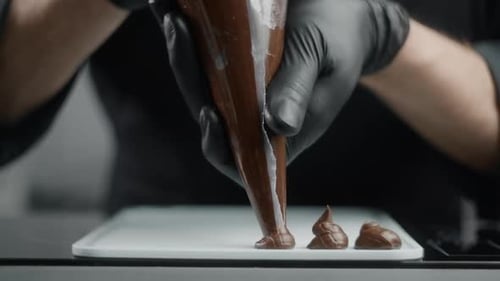 Pastry Chef Piping Delicate Dark Chocolate Shapes