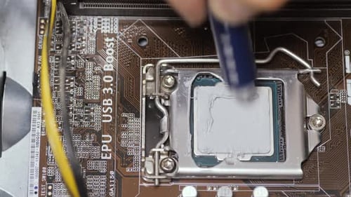 Techniker presst eine Wärmeleitpaste auf einen Desktop-Computerprozessor
