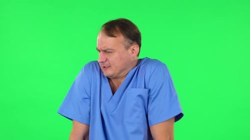 Un médecin s'est figé et a essayé de se réchauffer contre un écran vert.
