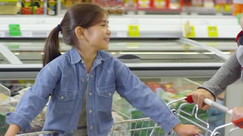 Girl Riding Shopping Trolley and Smiling