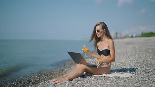 A Attractive Woman Blogger or Vlogger is Recording Content for Channel and Looking at Laptop and