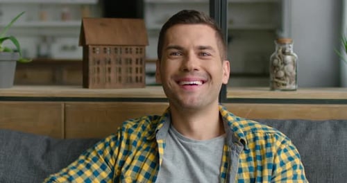 Smiling Young Adult Man Relaxing on Couch