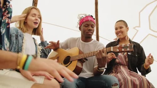 Young Adults Play Music Together Inside a Tent