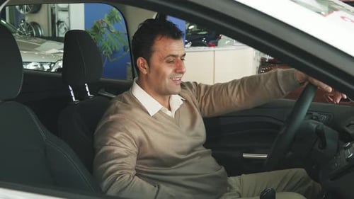Man Smiles in Car at Dealership